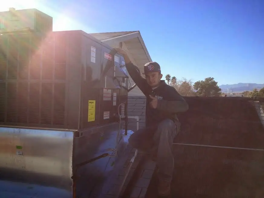 HVAC technician performing Heat Pump Repair on a rooftop unit in Pueblo West